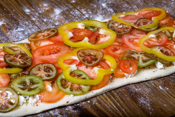 Homemade pie preparation recipe. Dough with cheese and vegetables on wood background
