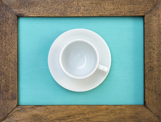 White ceramic coffee cup in wooden frame