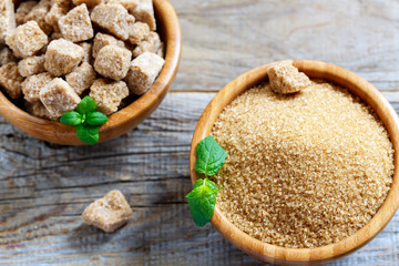 Small crystals of brown sugar in a wooden bowl.