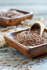 Wooden scoop in a bowl with brown flax.