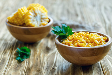 Canned sweet corn in a wooden bowl. - obrazy, fototapety, plakaty