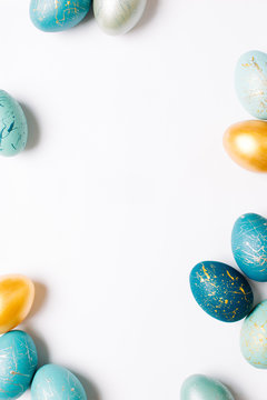 Frame background with gold and blue easter eggs with copy space for text
