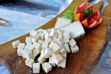 White cheese pieces on wooden tray. catering