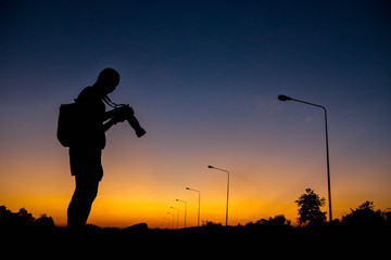 silhouette of a photographer who shoots a sunset.