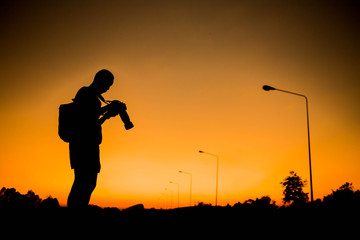 silhouette of a photographer who shoots a sunset.