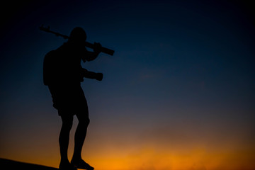 silhouette of a photographer who shoots a sunset.