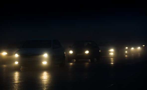 Headlights Of Cars Driving In Fog At Night