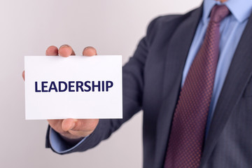 Man showing paper with LEADERSHIP text