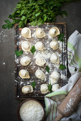 Traditional pelmeni or dumpling at cutting board.