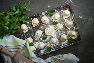 Traditional homemade pelmeni or dumpling at cutting board.