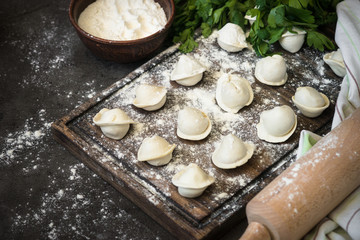 Fototapeta na wymiar Traditional homemade pelmeni or dumpling at cutting board.