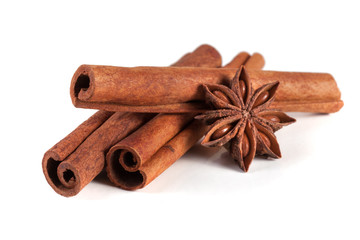 three cinnamon sticks with star anise isolated on white background