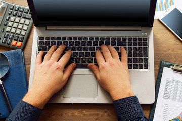 Fototapeta premium Analyzing financial data and counting on computer. Male hands working on the keyboard of a computer