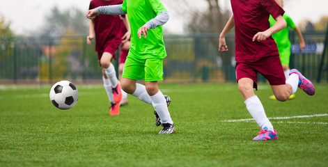 Obraz premium Football Soccer Match for Children. Kids Playing Soccer Game Tournament. Boys Running and Kicking Football on the Sports Grass Field