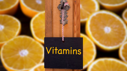 blackboard with word Vitamins hanging in front of sliced oranges