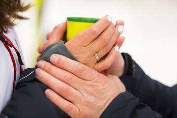 Руки мужчины согревают руки женщины с кружкой/чашкой горячего чая  © bellefotos