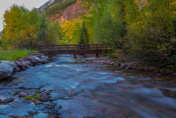 Naklejka na ściany i meble Flowing River Under Bridge near Aspen Colorado in Autumn