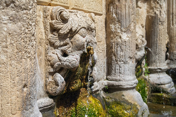 Fototapeta na wymiar Stone lions head close-up of the Rethymno old town Rimondi Fountain.