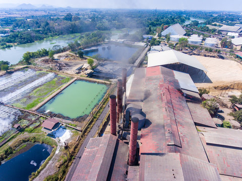 Aerial shot of sugar factory and smoking chimneys. Industrial landscape.