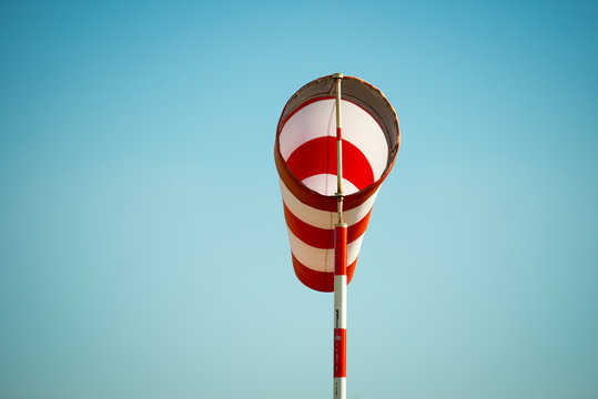 Horizontally flying windsock (wind vane) due to high wind. Blue sky in the background. Success concept.