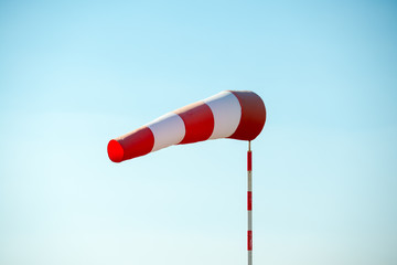 Horizontally flying windsock (wind vane) due to high wind. Blue sky in the background. Success concept.