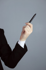 Business hand pointing on a gray background. A pen