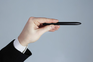 Business hand pointing on a gray background. A pen
