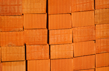 Closeup of red clay bricks stacked in piles