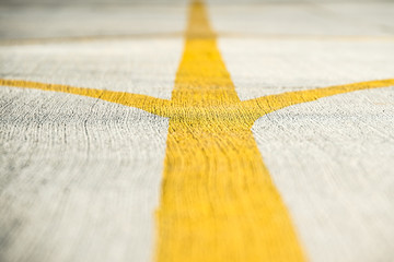 Yellow direction strips closeup on an airfield runway.