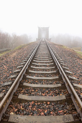 Fototapeta premium railroad goes into the mist. gray misty autumn morning.