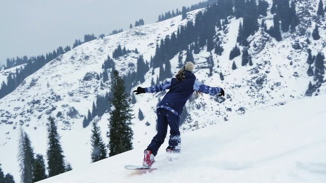 Extreme snowboarder woman riding by powder at mountain backcountry. Snowboarding, winter activities