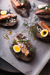 Sardines, quail egg on rye bread top view