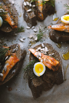 Sandwiches with sardines and quail eggs partial blur