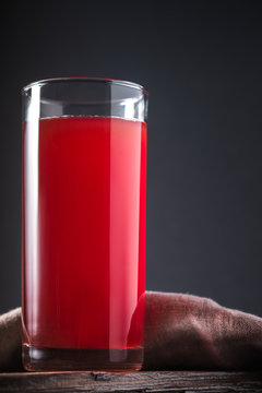 Cranberry drink in high glass on a grey background