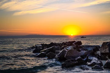 Fotobehang Sunrise. The sea and large stones © Aleksandr