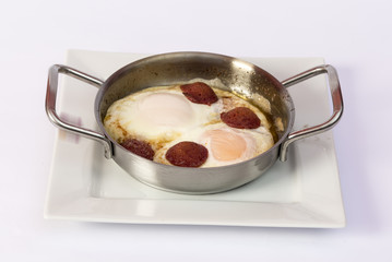 Fried eggs with sausage in pan