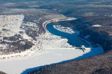 Hydropower station on the mountain river in winter, top view