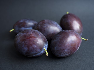 Purple plums isolated on dark background
