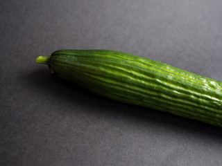 Half of cucumber on dark background