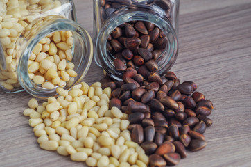 Pine nuts are peeled and unpeeled together in a heart shape scattered from the jars