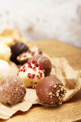 Selection of delicious chocolates on a rustic background