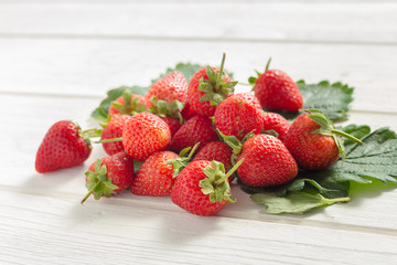 Fresh strawberries on white wooden table.