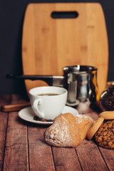 a wooden board and an iron ladle, a mug with a drink and a cupcake