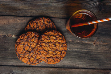oatmeal cookies in chocolate glaze and a glass with a drink