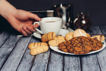 oatmeal cookies with chocolate icing and a cup in hand