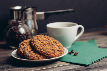 oatmeal cookies on a wooden background and a mug with a drink