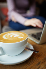Two cups of coffee and cake on the table, latte art