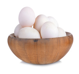 Eggs in wooden bowl isolated on white background.