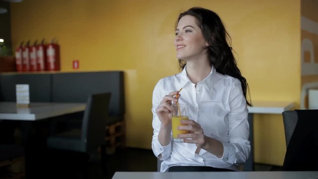 Pretty woman drinking fresh juice in cafe
