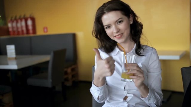 Pretty woman drinking fresh juice in cafe